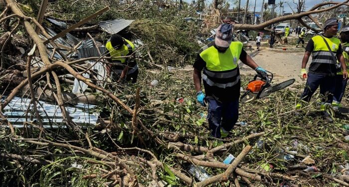 Rescue workers attempt to clear a blocked road, in the aftermath of Cyclone Chido, in Mayotte, France