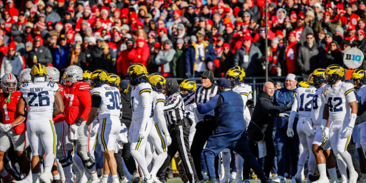 Ohio State Buckeyes players scuffle with Michigan Wolverines in the field.