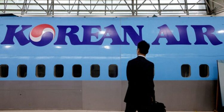 © Reuters. FILE PHOTO: A man walks next to the logo of Korean Air airlines during an organised media tour, at the company's Cabin Crew Training Center in Seoul, South Korea, June 27, 2024. REUTERS/Kim Soo-hyeon/File Photo